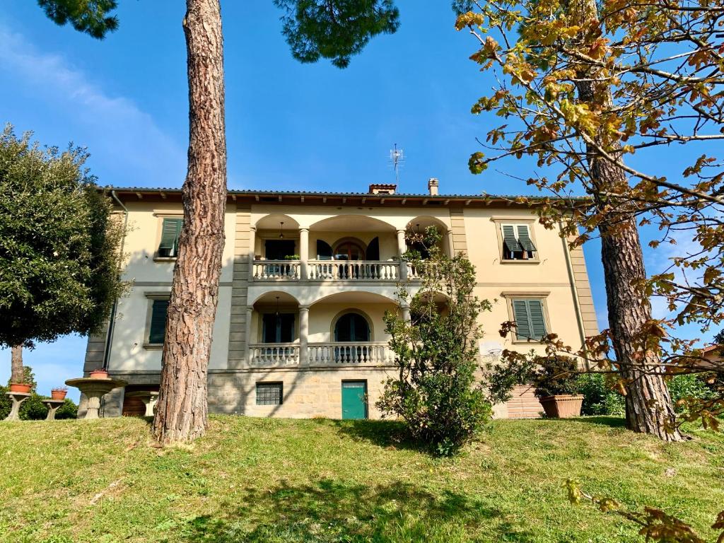 uma casa grande numa colina com árvores em Villa dei Pini em Montopoli in Val dʼArno
