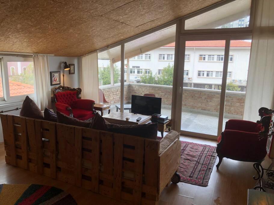 a living room filled with furniture and a large window at TARİHİ KALEİÇİ MUHTEŞEM DİZAYN HUZURLU KEYİFLİ TERAS KEYİFLİ ÖZEL ev in Antalya