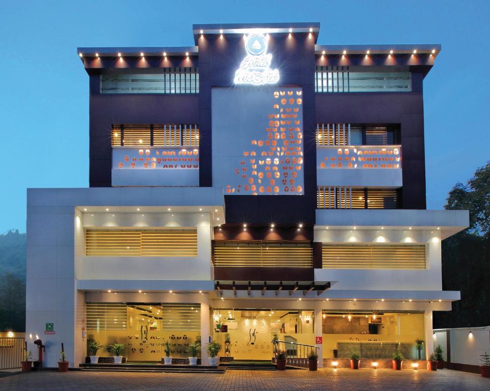 a building with a christmas tree on the side of it at Hotel NovArk Munnar in Kallar Vattiyar