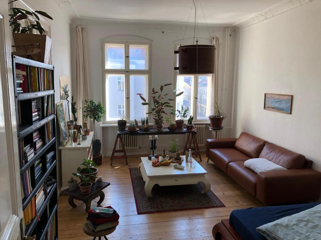 a living room with a couch and a coffee table at heller großer jugendstil altbau in berlin tempelhof in Berlin