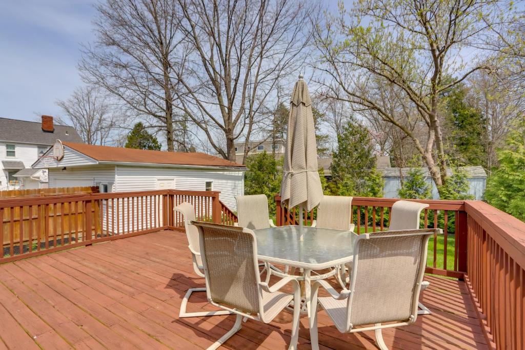 un patio con una mesa y una sombrilla en una terraza en Chic Home with Deck, Walk to Lake Erie!, 