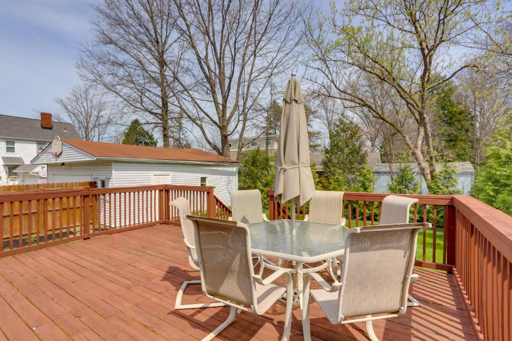 a patio with a table and an umbrella on a deck at Chic Home with Deck, Walk to Lake Erie! 