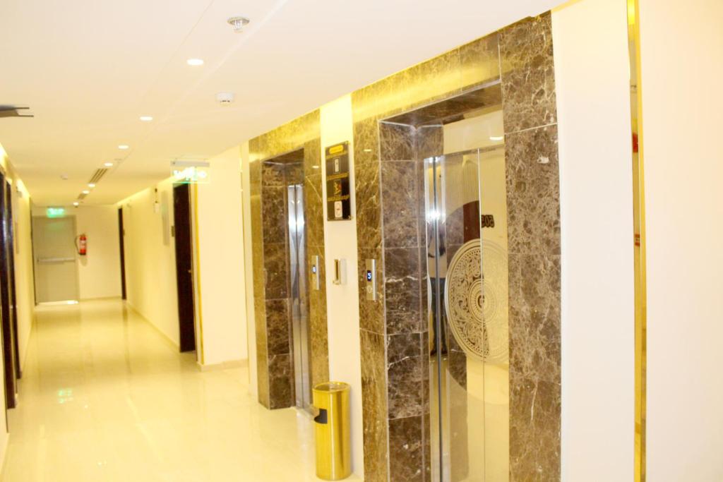un pasillo en un edificio con puerta de cristal en فندق العزم, en Hafr Al Batin