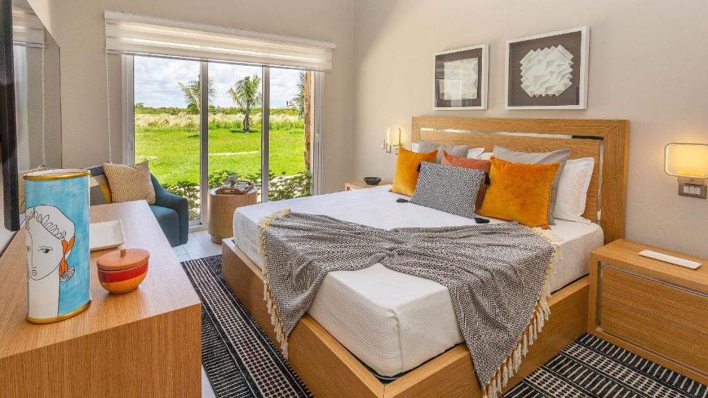 een slaapkamer met een bed en een raam bij Luxury Pool & Golf View Aptin in Hard Rock Golf PC in Punta Cana