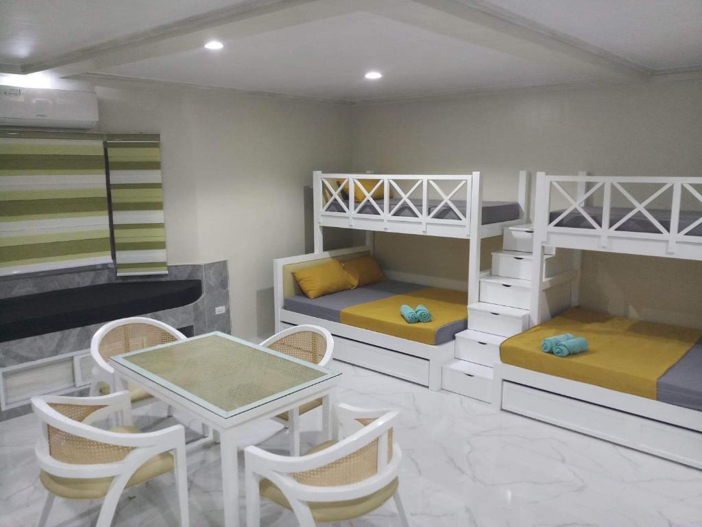 a room with bunk beds and a table and chairs at Michaels Homestay - Farm Villa nr Patar Beach & Bolinao Falls in Bolinao