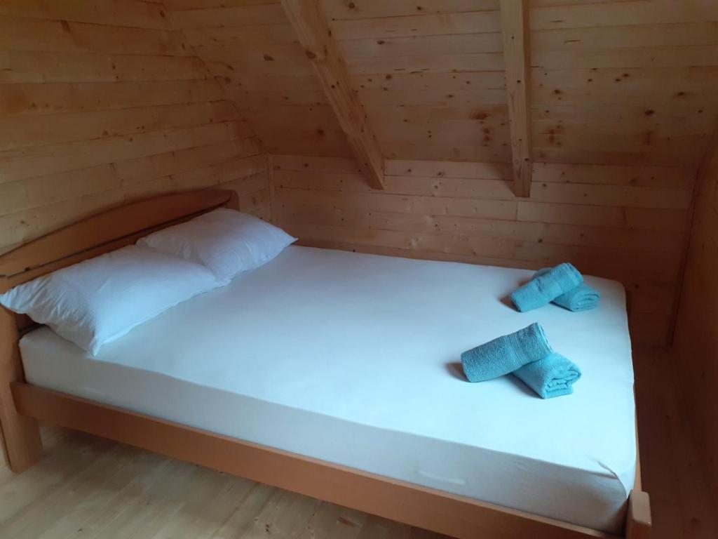 a bed in a wooden cabin with two pillows on it at Vila Bella, Tara, Zaovinsko jezero in Zaovine