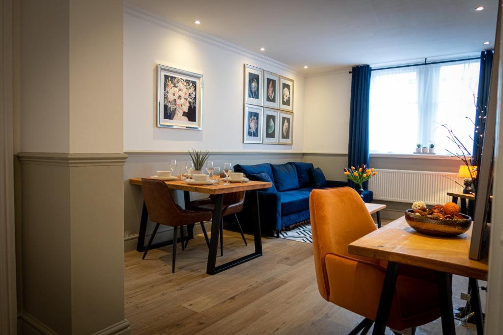 uma sala de estar com uma mesa e um sofá azul em Stylish Apartment close to Beach & Town Centre em Prestatyn