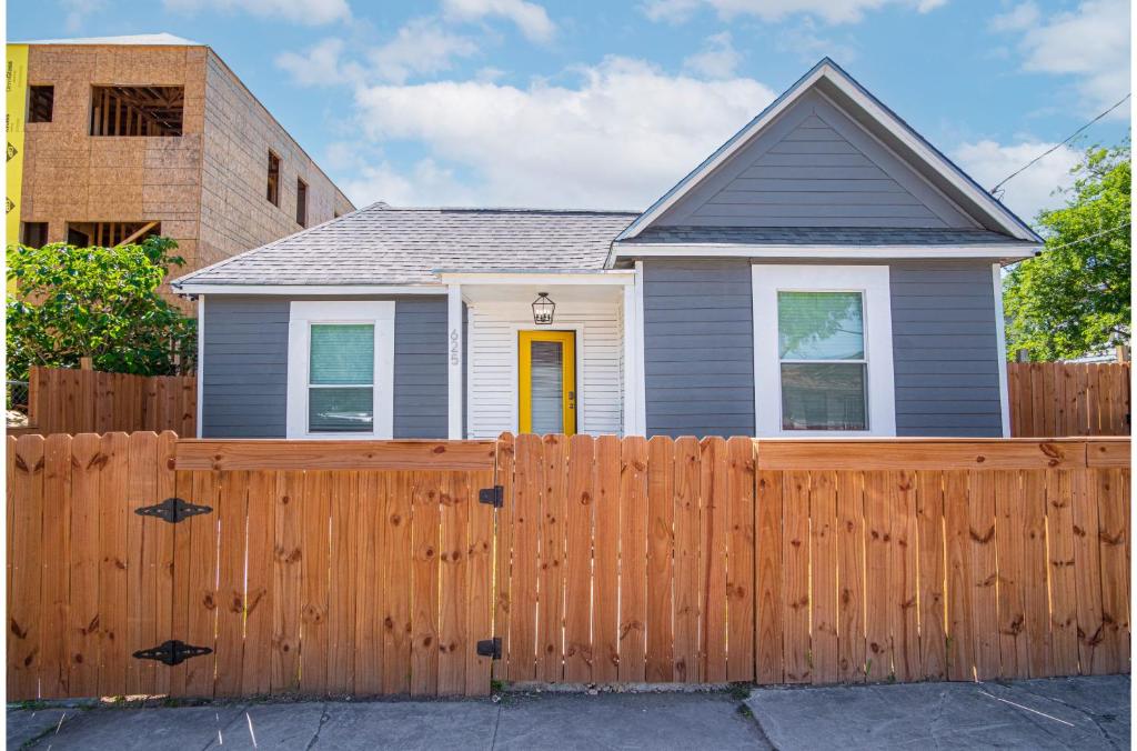 a house behind a wooden fence at Charming 4BR2BA Only 5 mins Downtown Riverwalk in San Antonio