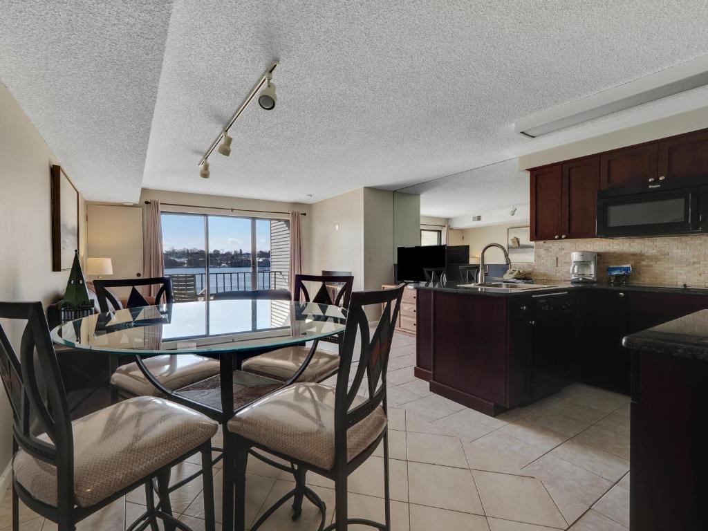 a kitchen and dining room with a glass table and chairs at 223 Edgewater Inn in Charlevoix