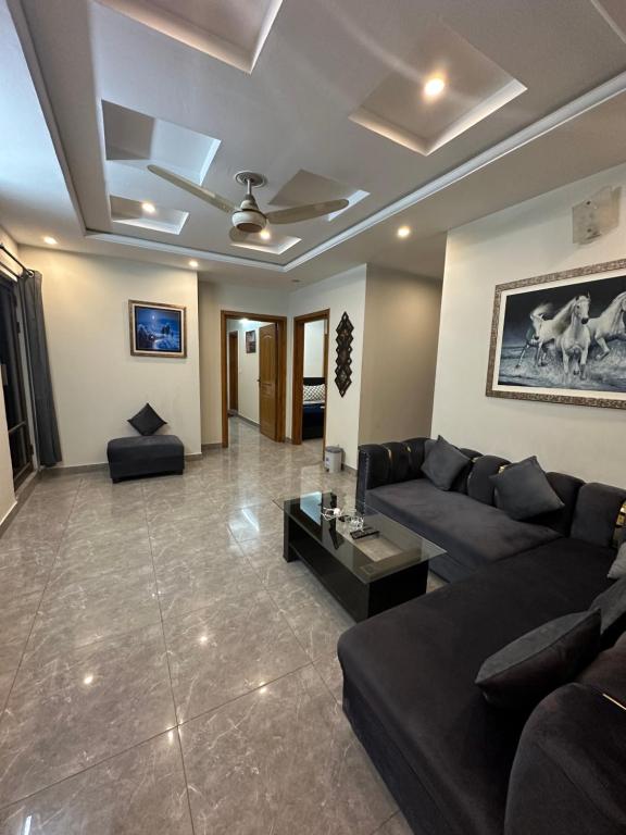 een woonkamer met een bank en een tafel bij The Penthouse 2BHK in Islamabad