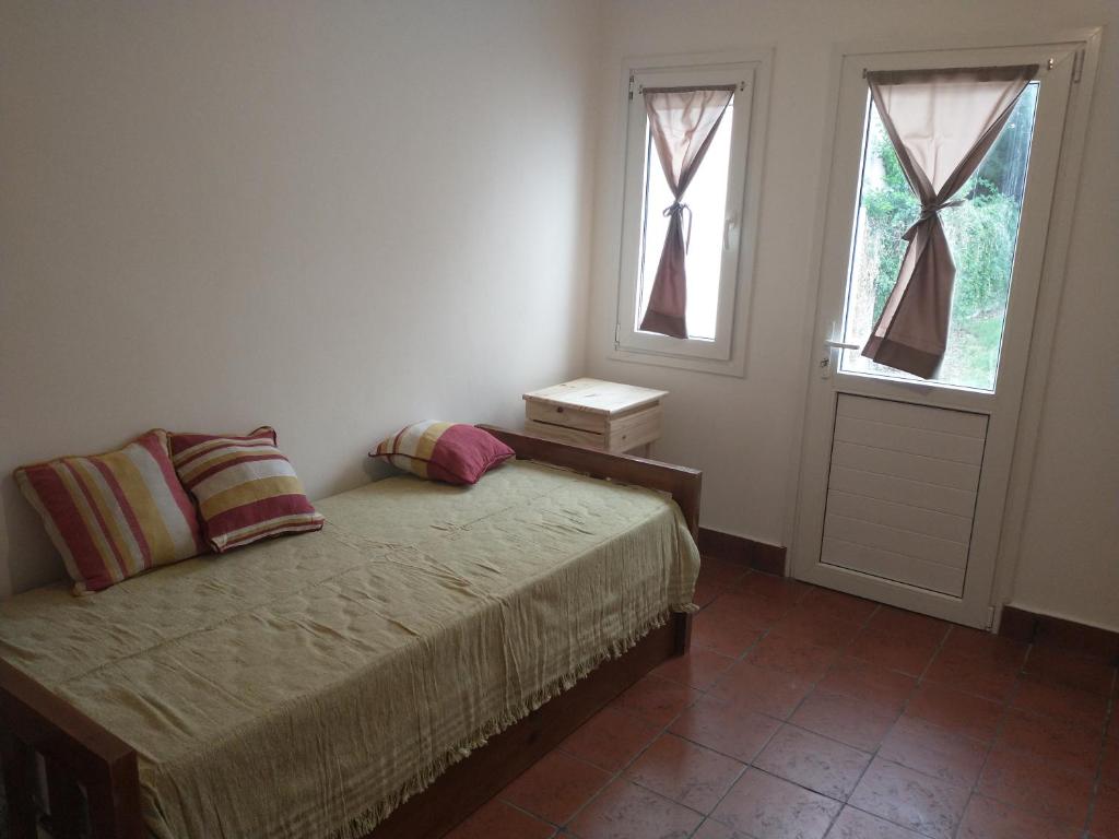 1 dormitorio con 1 cama con 2 almohadas y ventana en Coneta, casa de Dios en San Fernando del Valle de Catamarca