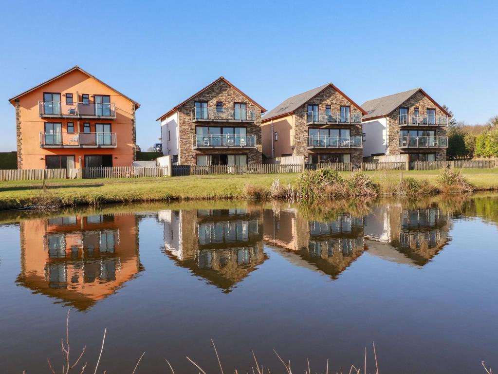 a row of houses next to a body of water at 207 The Glades - Retallack Resort and Spa in Saint Columb Major