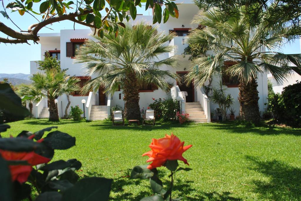a house with palm trees and a flower in the yard at Antigoni Apartments 'Olive Room' in Milatos