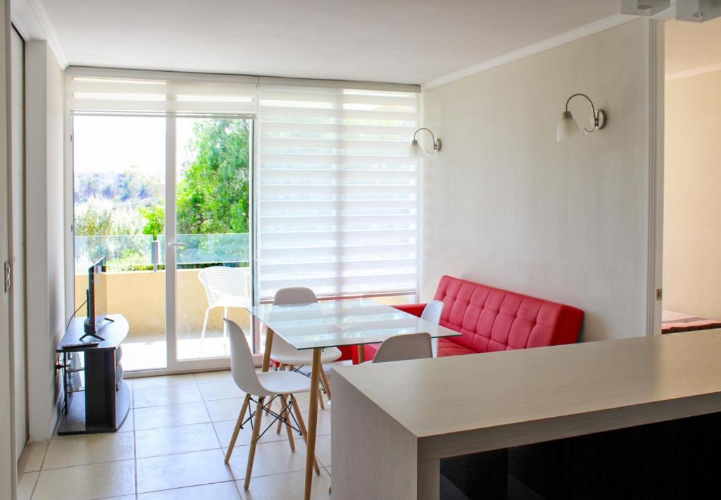ein Wohnzimmer mit einem roten Sofa und einem Tisch in der Unterkunft Condominio Vista Azapa Piso 2 Dto 24 in Arica