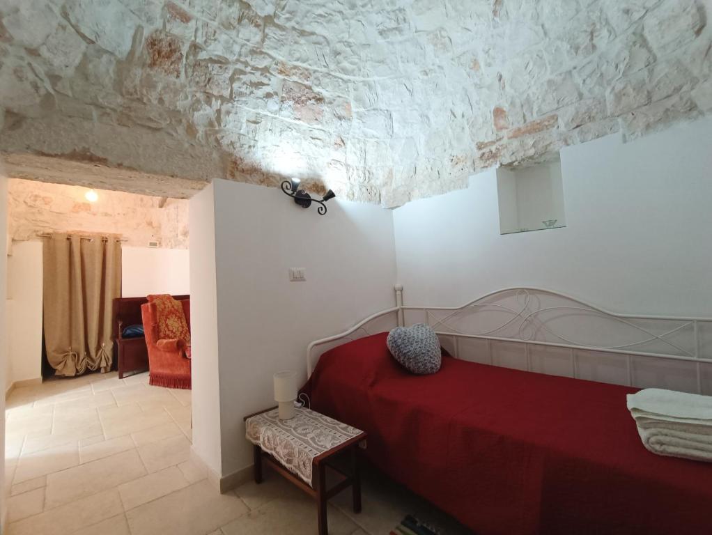 a bedroom with a red bed and a ceiling at Trulli Belvedere in Putignano