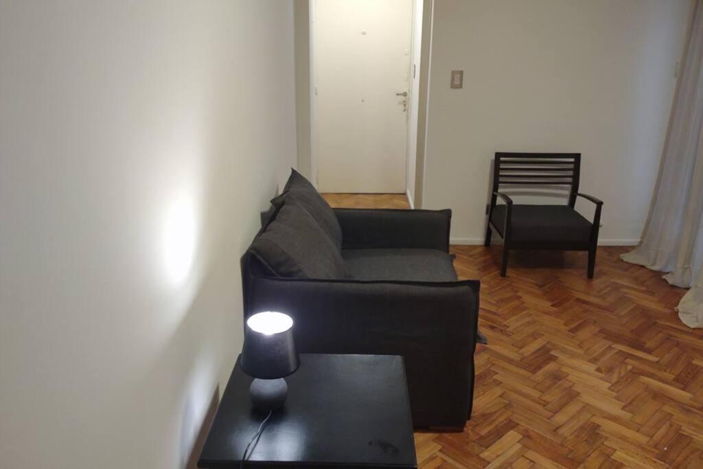 uma sala de estar com um sofá preto e uma mesa em Departamento de 2 ambientes en Recoleta 4 piso em Buenos Aires