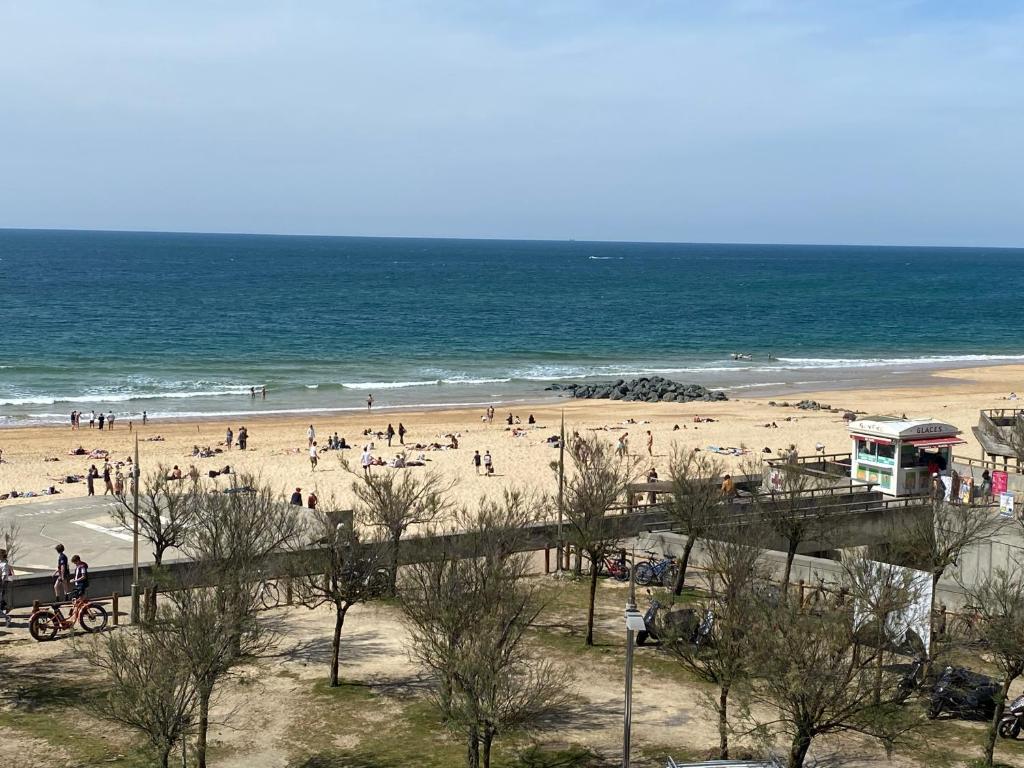 a group of people on a beach near the ocean at Appartement vue mer Hossegor in Soorts-Hossegor