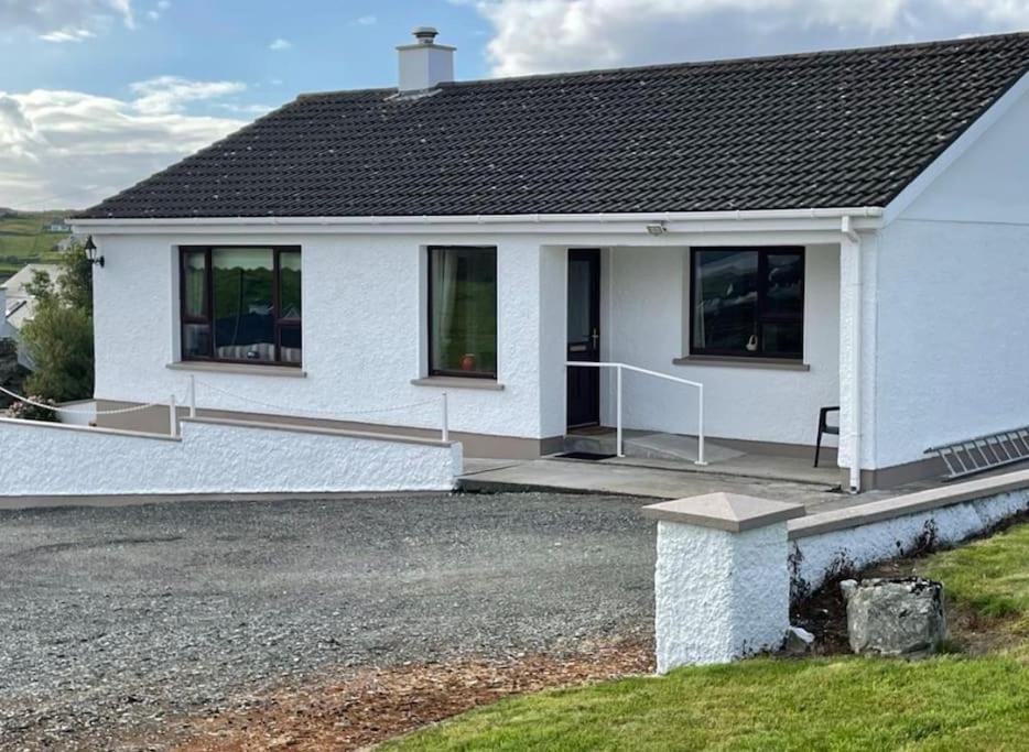 una casa blanca con una entrada delante de ella en Heather Hill Cottage en Downings