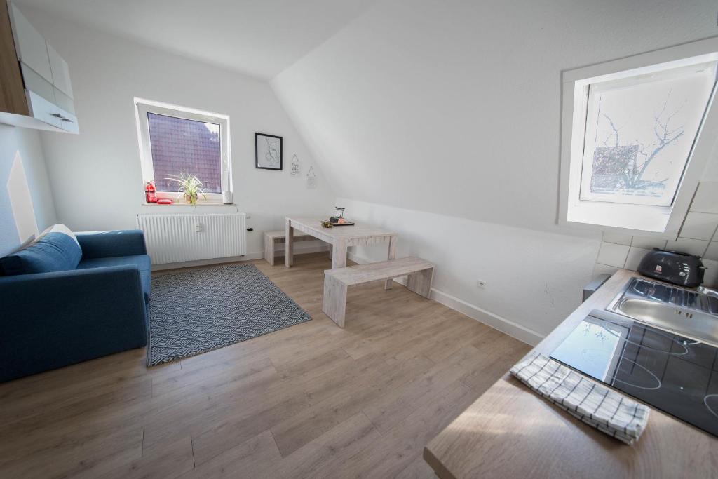 ein Wohnzimmer mit einem blauen Sofa und einem Tisch in der Unterkunft KobyApartment in Herford