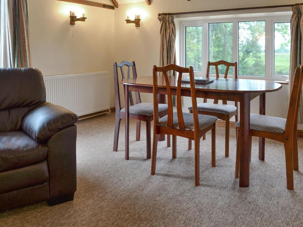 sala de estar con mesa, sillas y sofá en Stable Cottage 8 - Ukc3747 en Bawdeswell