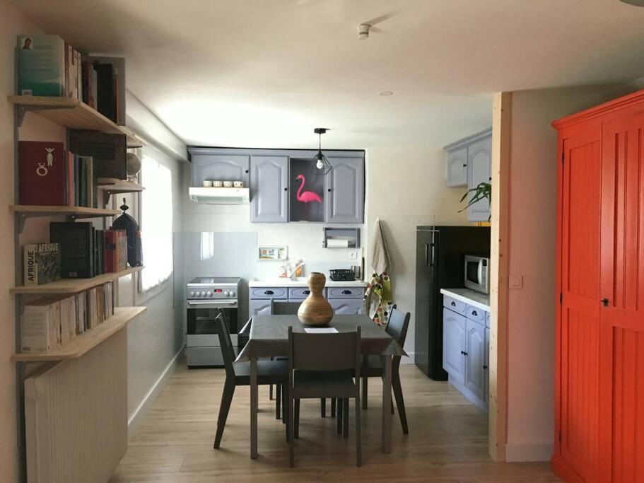 une cuisine avec une table et des chaises dans une pièce dans l'établissement La maison du Lhéris, à Bagnères-de-Bigorre