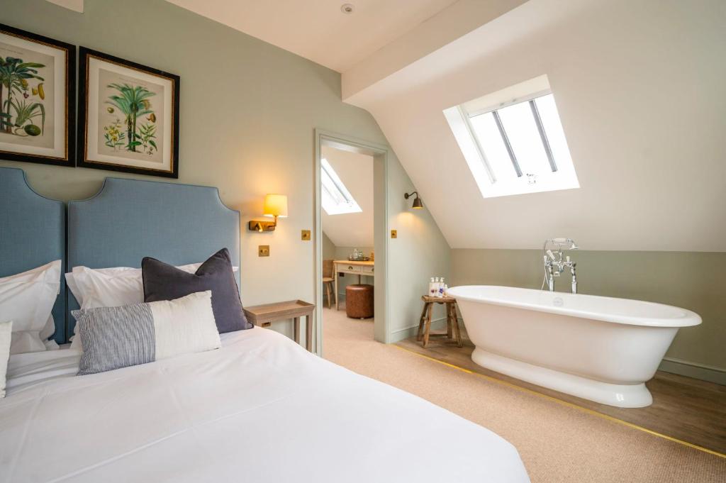 ein Schlafzimmer mit einem großen Bett und einer Badewanne in der Unterkunft The Bottle & Glass Inn - Deluxe Room - Room 3 in Henley on Thames