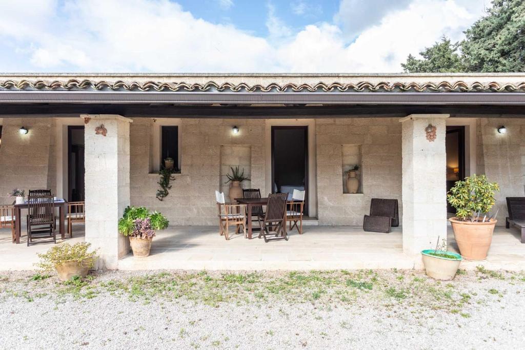 Cette maison dispose d'une terrasse avec une table et des chaises. dans l'établissement Agriturismo De Lorenzi, à Casarano