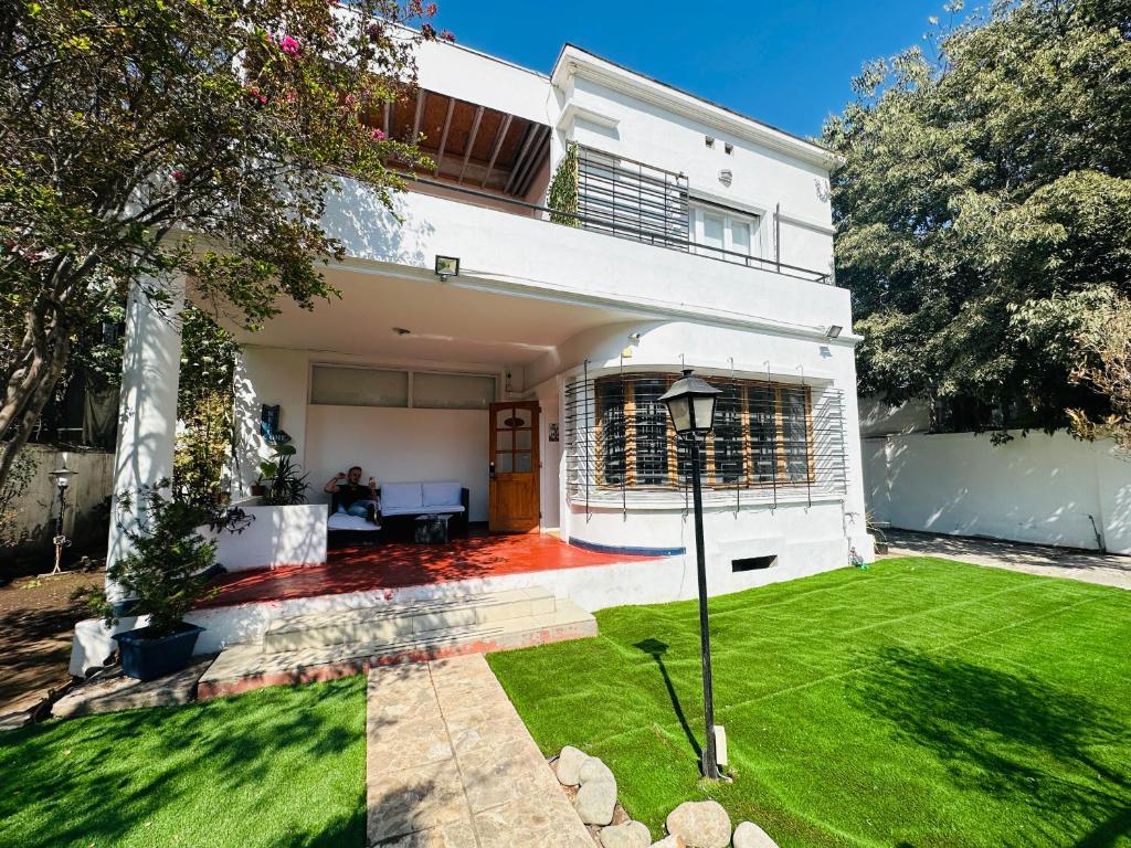 a white house with a lawn in front of it at Maktub Europa - Hostal Boutique in Santiago