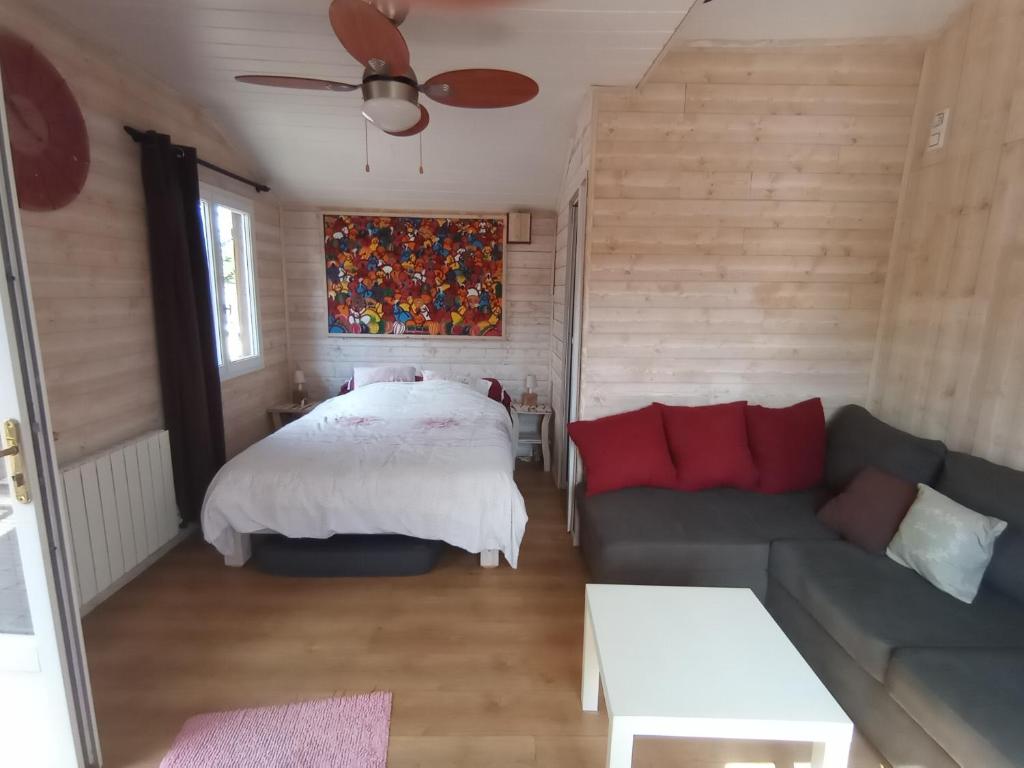 uma sala de estar com uma cama e um sofá em CHALET em La Guierche