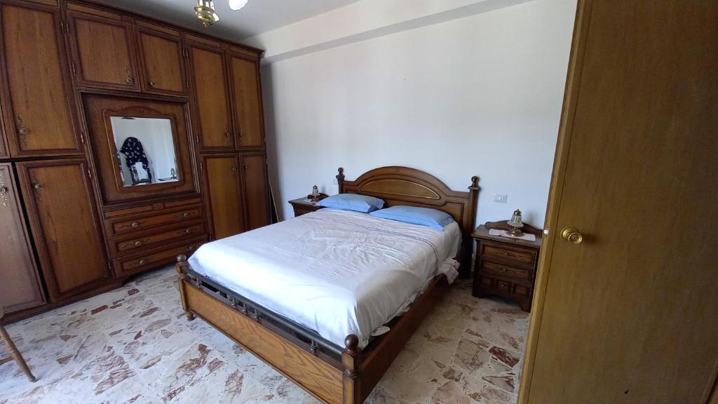 a bedroom with a bed and two dressers in it at Appartement Spadafora - 50m de la plage in Spadafora