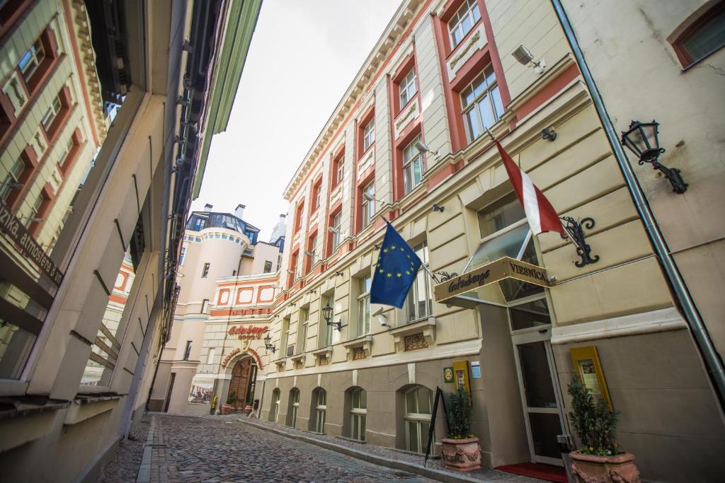 an alley with flags on the side of a building at Hotel Gutenbergs in Rīga