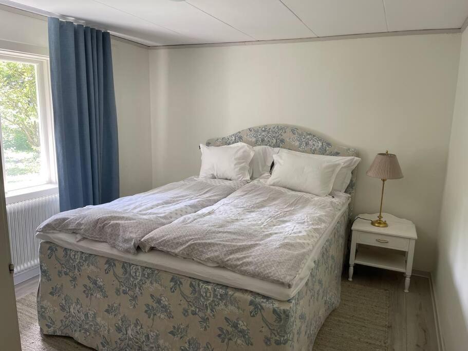 1 dormitorio con 1 cama con edredón azul y blanco en Slottsnära miljö. en Laholm