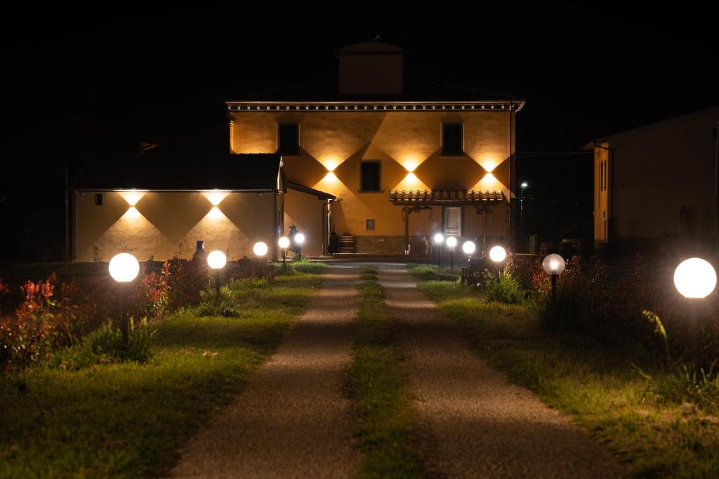 einen Weg, der nachts zu einem Haus mit Lichtern führt in der Unterkunft Casale Il Terranova in Cortona