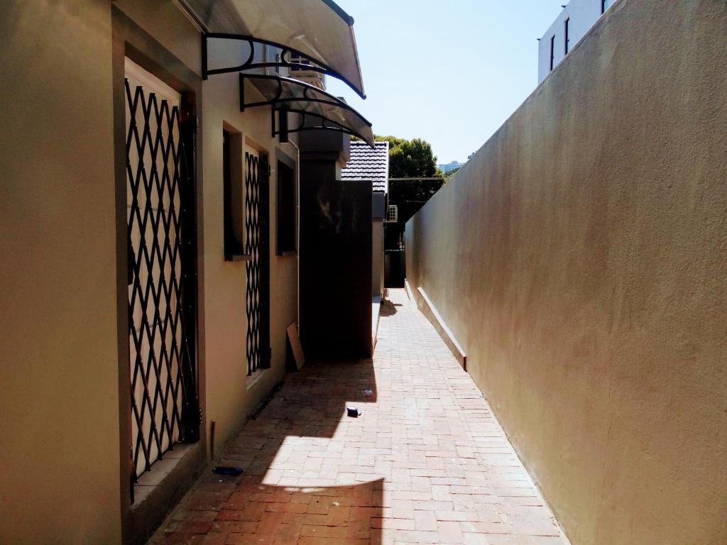 an alley way with a door and a brick sidewalk at 136 on 4th in Johannesburg