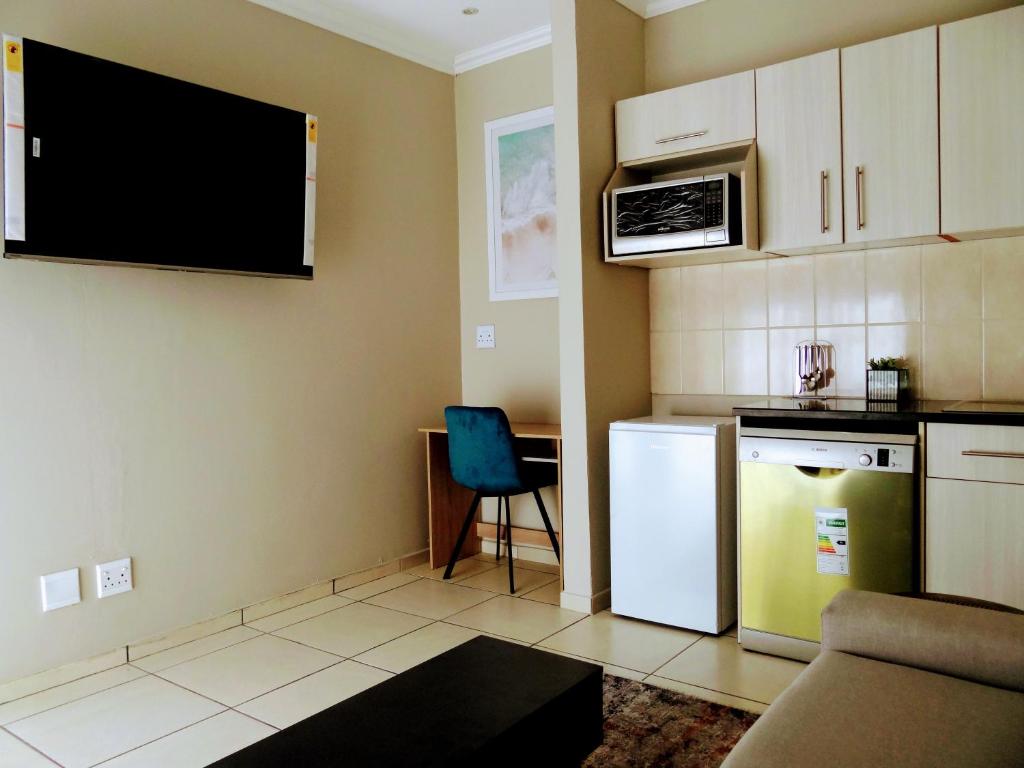 a kitchen with a white refrigerator and a microwave at 136 on 4th in Johannesburg