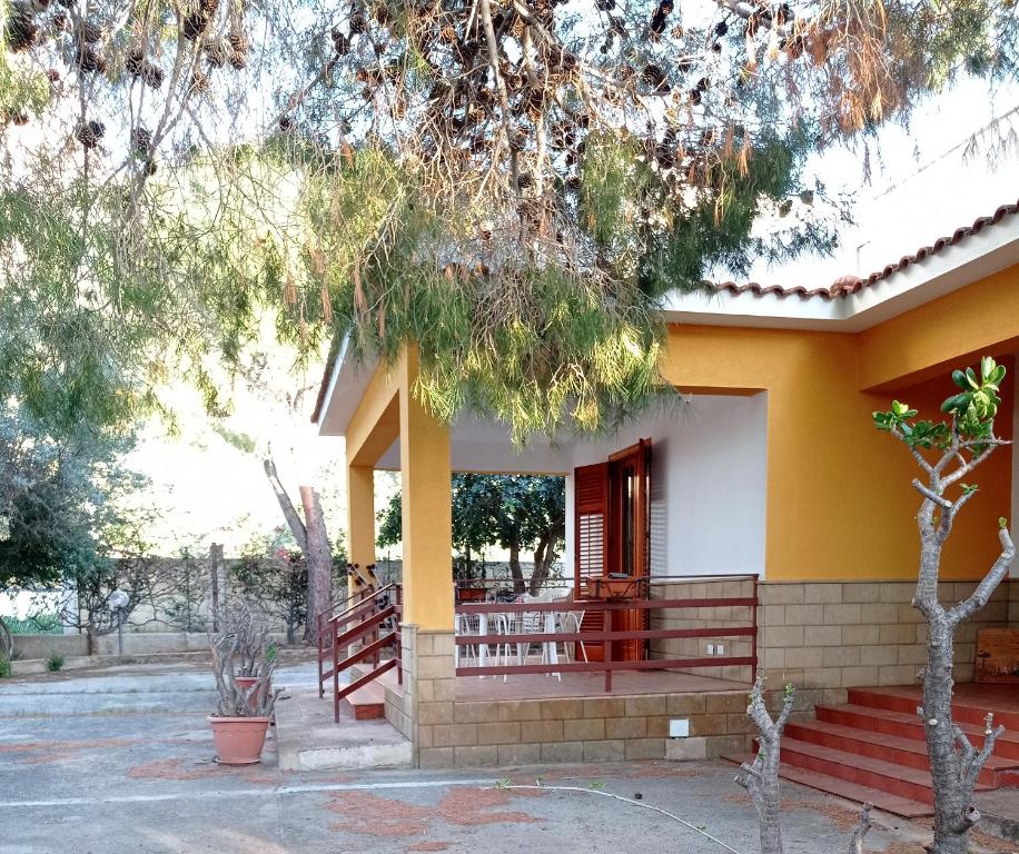 a house with a yellow and white at Sunset Cottage in Cinisi