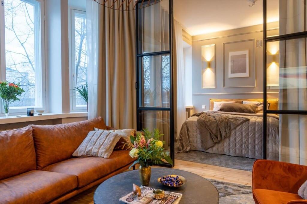 uma sala de estar com um sofá e uma cama em Luxury Getaway - One-Bedroom Suite w Fireplace em Helsinque