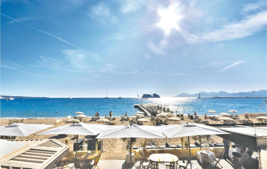 - une plage avec des parasols blancs et l'océan dans l'établissement 1 Bedroom Lovely Apartment In Cannes, à Cannes