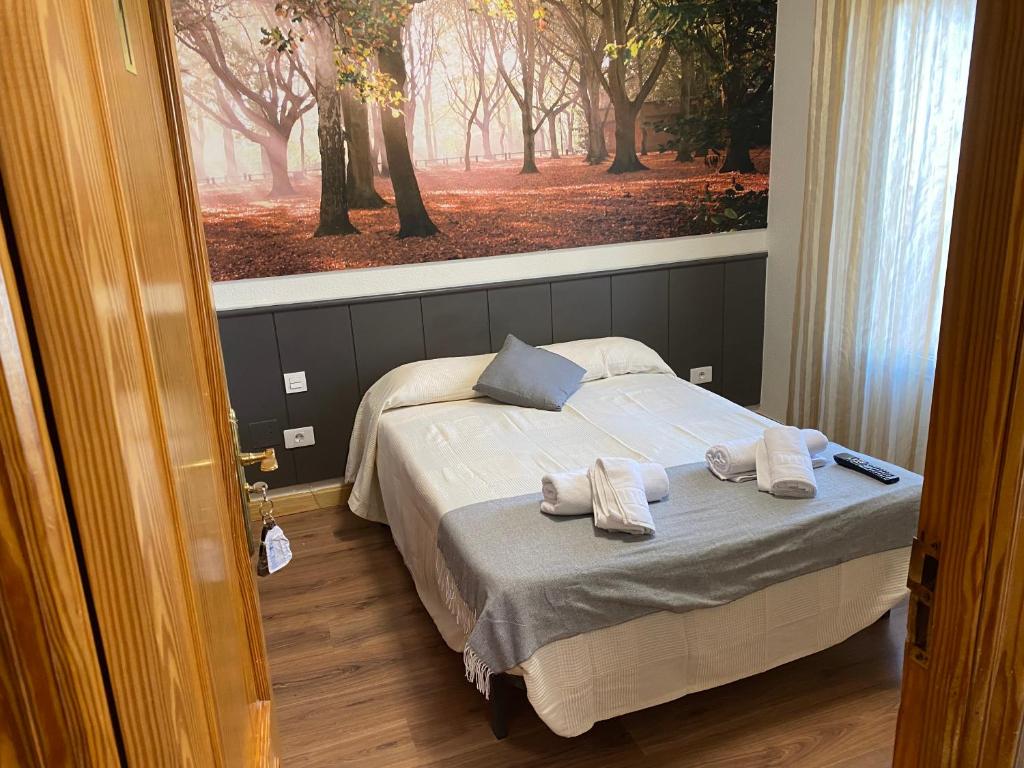 1 dormitorio con 1 cama con 2 toallas en Hostal Restaurante Río Ubierna, en Quintanilla-Vivar