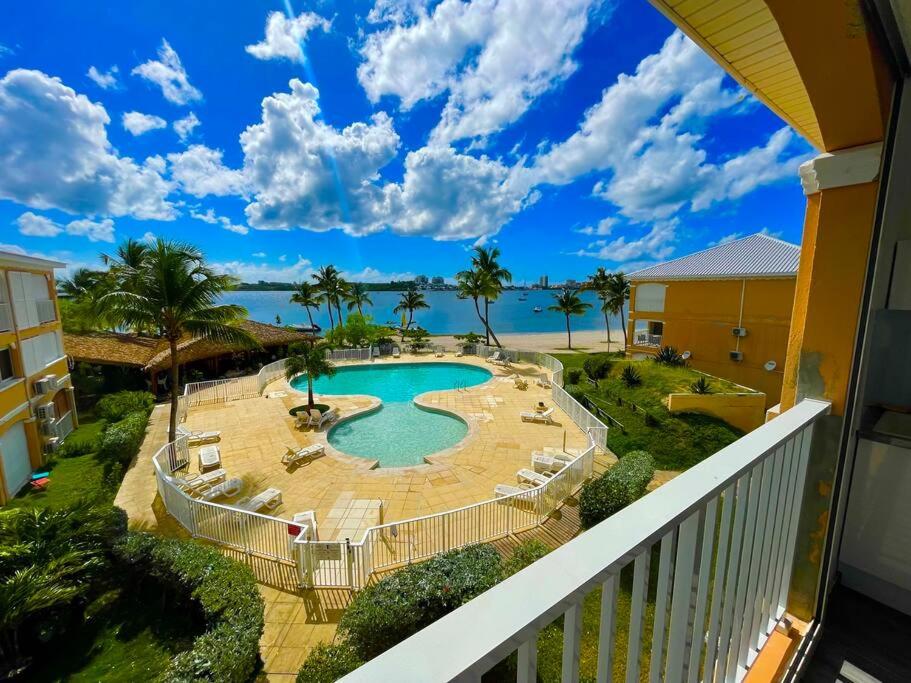 Elle comprend un balcon offrant une vue sur la piscine et l'océan. dans l'établissement Superbe studio lumineux, vue sur piscine et mer, à Baie Nettlé