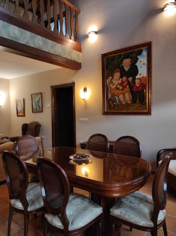 un comedor con una mesa y una pintura en la pared en Casa Felisa Pirineo Aragonés en Santa Eulalia de Gállego