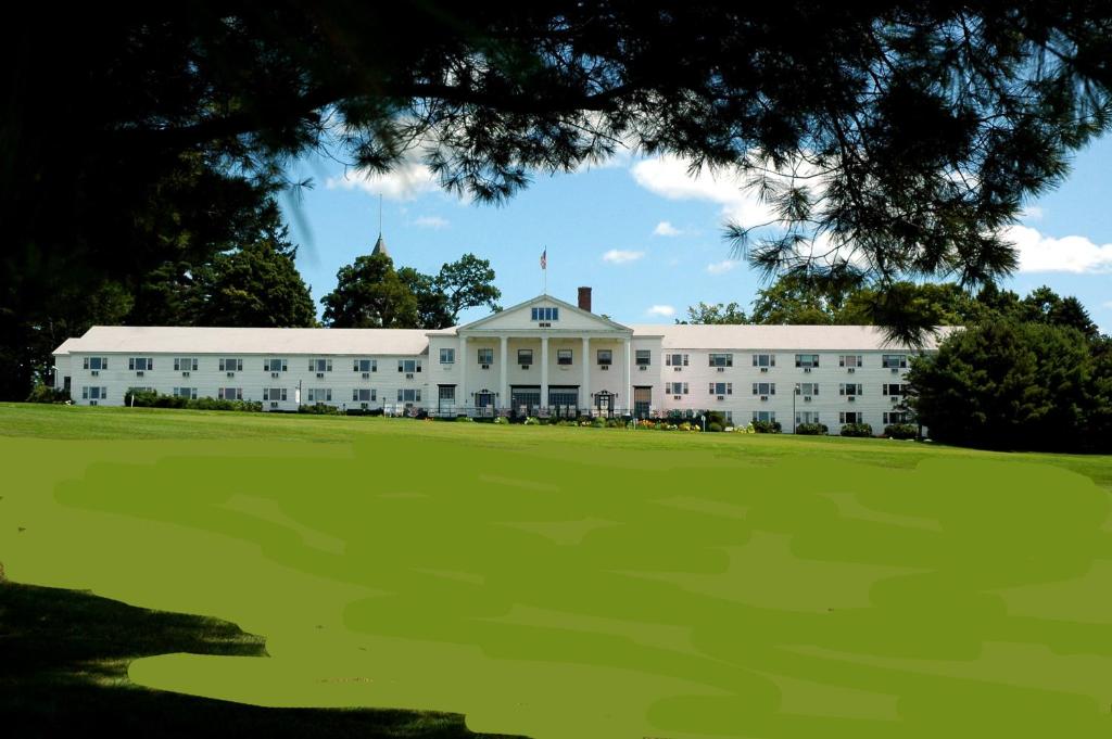 a large white building with a green field in front at The Maine Inn at Poland Spring Resort in Poland
