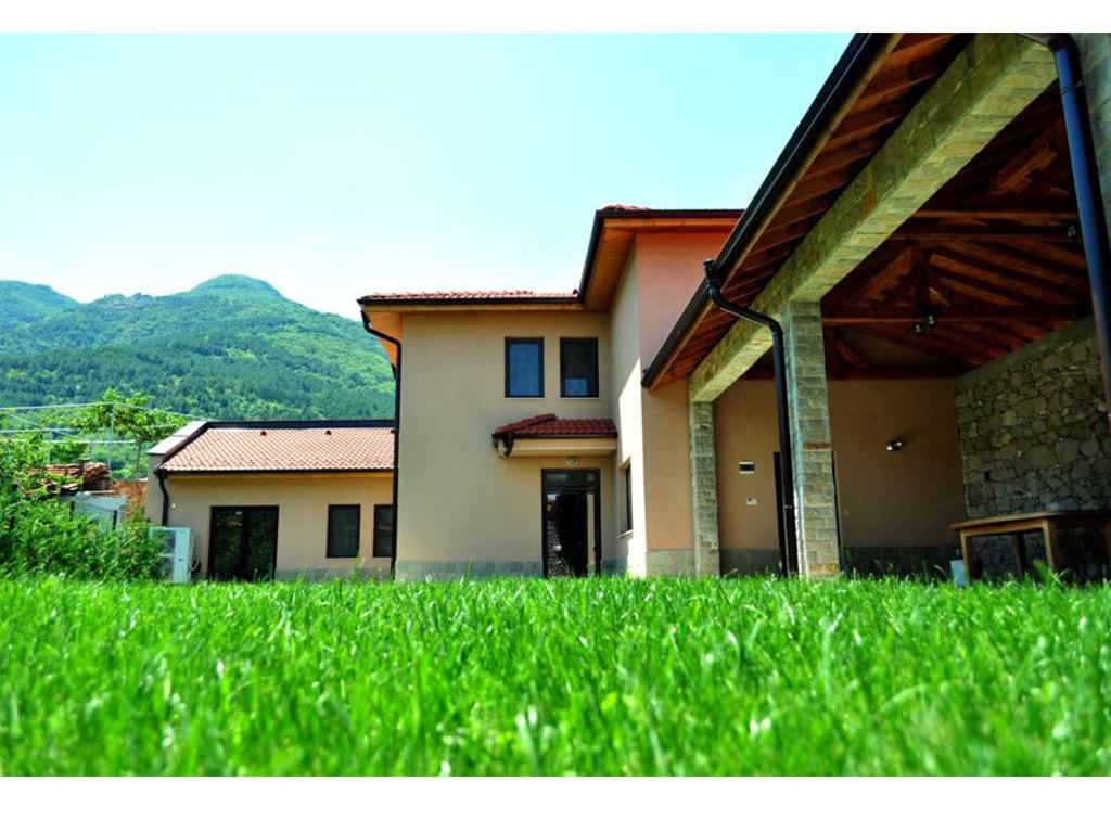 a house with green grass in front of it at Yustina Villas Guest House in Ustina