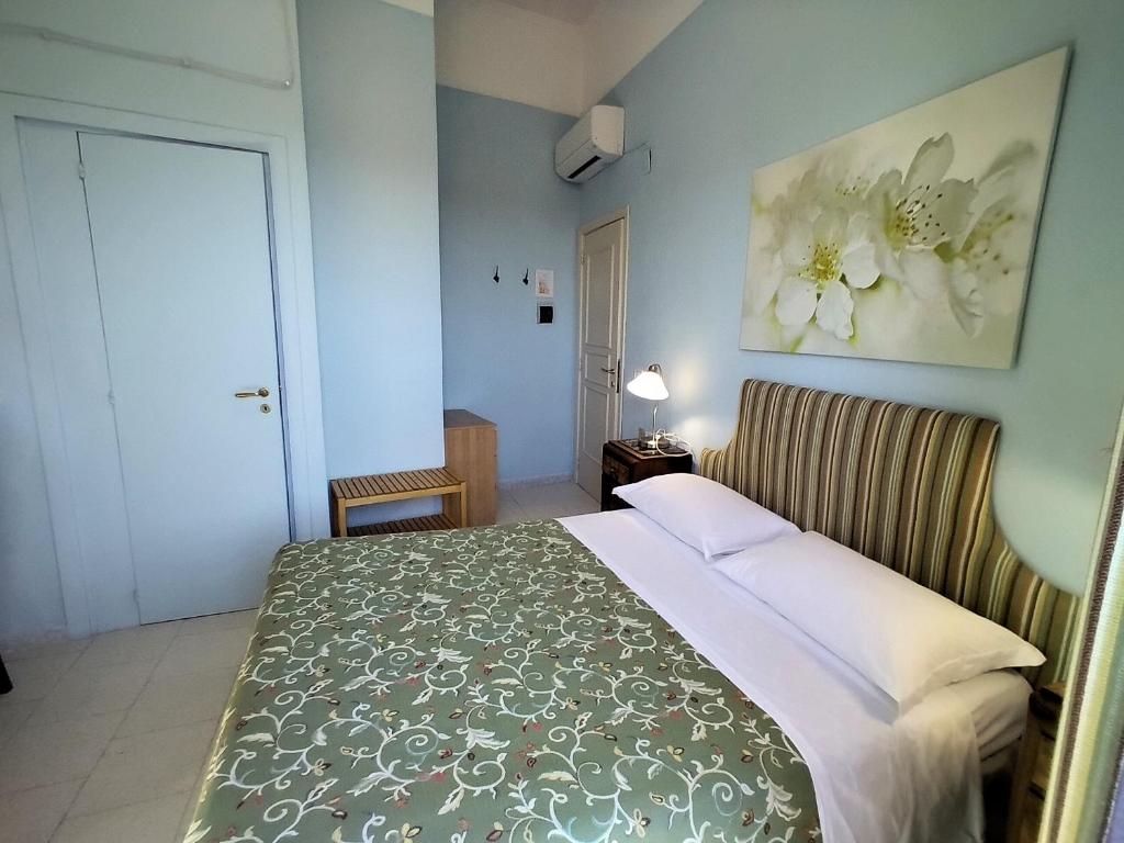 カステッラバーテにあるafra Bed & Breakfastのベッドルーム1室(花の絵が飾られたベッド1台付)