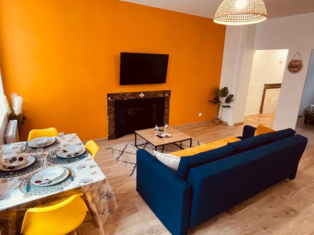 a living room with a blue couch and a fireplace at Le Ch'ti Cambrai - Love, Centre ville in Cambrai