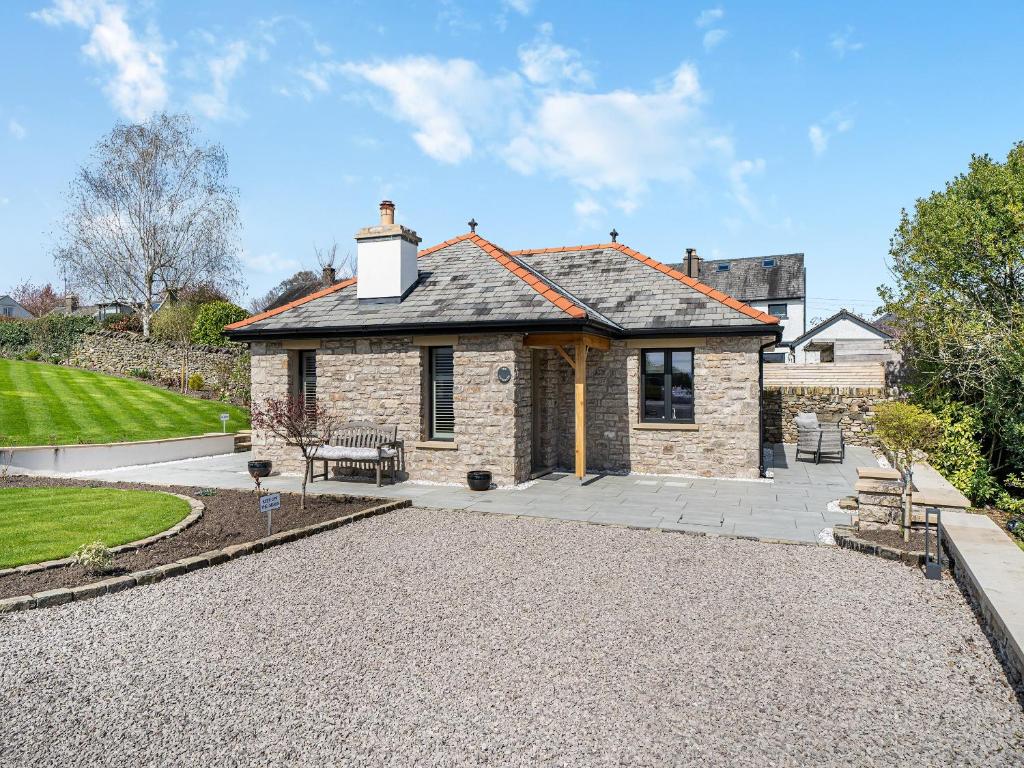 ein Steinhaus mit einer Terrasse davor in der Unterkunft The Outhouse in Kendal