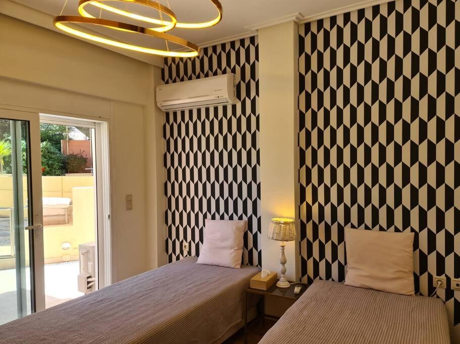 1 Schlafzimmer mit 2 Betten und einem Kronleuchter in der Unterkunft Aelia luxury apartment with private entrance in Karavomylos