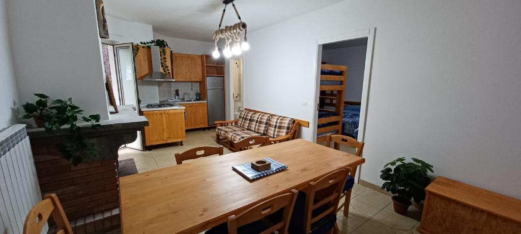 a kitchen and living room with a wooden table and chairs at La Casa di Chicca in Camigliatello Silano