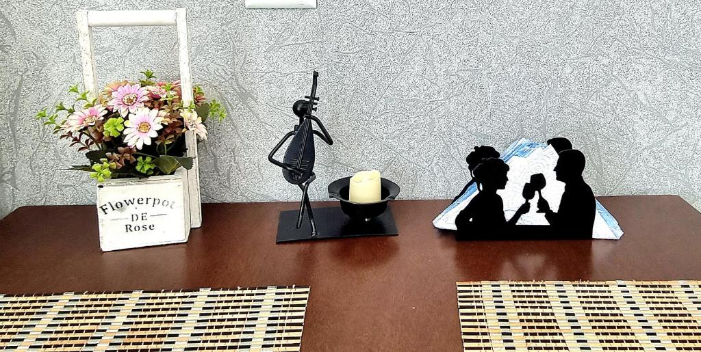 a table with a couple figurine and a candle and flowers at Kate's cozy apartment in Kutaisi