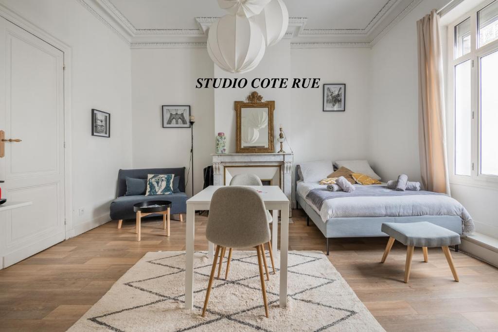 - une chambre avec un lit, une table et des chaises dans l'établissement Les Appartements à Gambetta, à Bordeaux